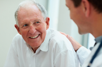 Happy old man having a casual talk with a doctor