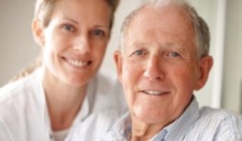 Closeup of a happy retired man on the wheel chair with a nurse