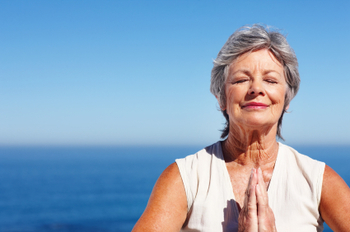 Woman practicing yoga with ocean in background