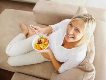 Top-down view of woman eating fruit salad